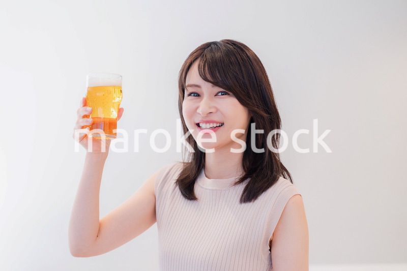 笑顔でビールを飲む若い女性