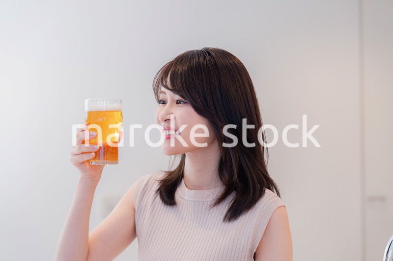 笑顔でビールを飲む若い女性