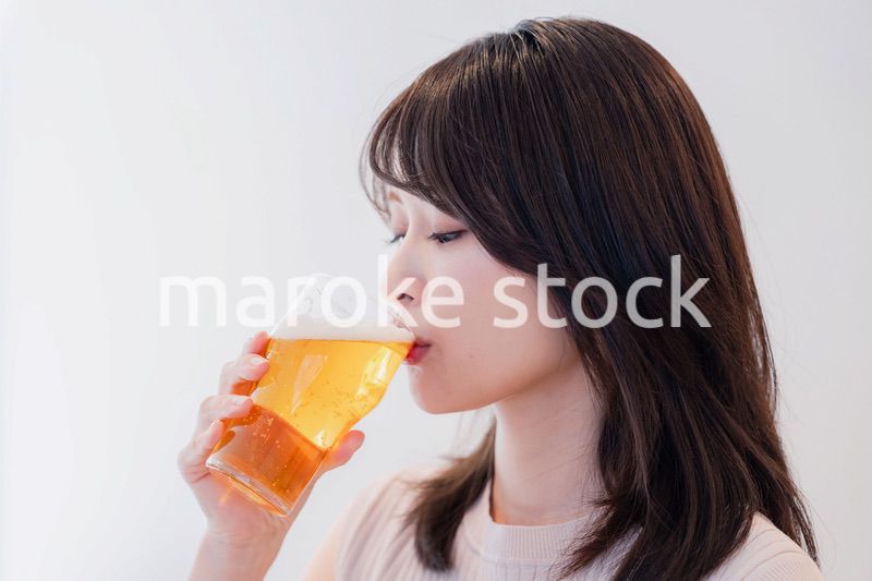 笑顔でビールを飲む若い女性