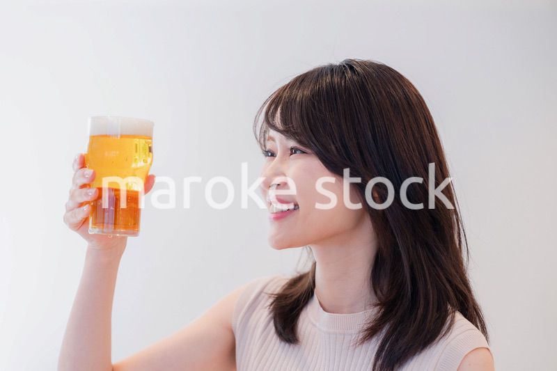 笑顔でビールを飲む若い女性