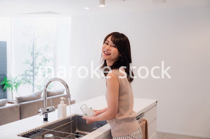 キッチンで洗い物をする若い女性