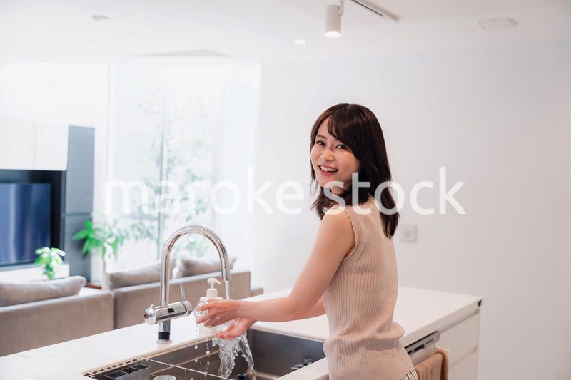 キッチンで洗い物をする若い女性