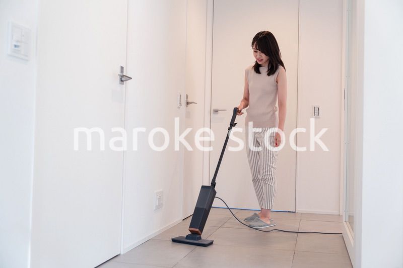掃除機で家の掃除をする若い女性