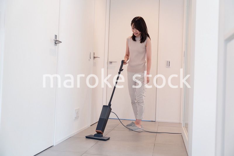 掃除機で家の掃除をする若い女性