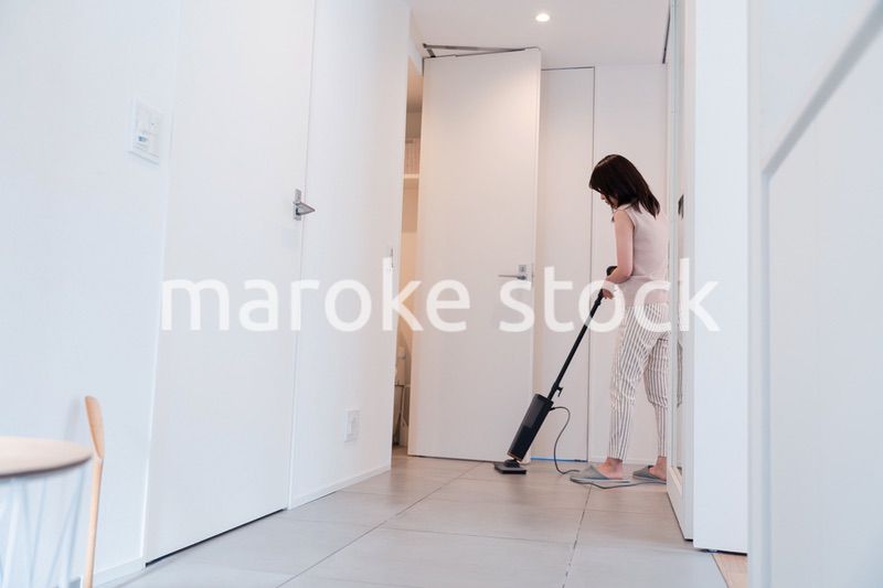 掃除機で家の掃除をする若い女性
