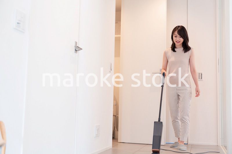 掃除機で家の掃除をする若い女性