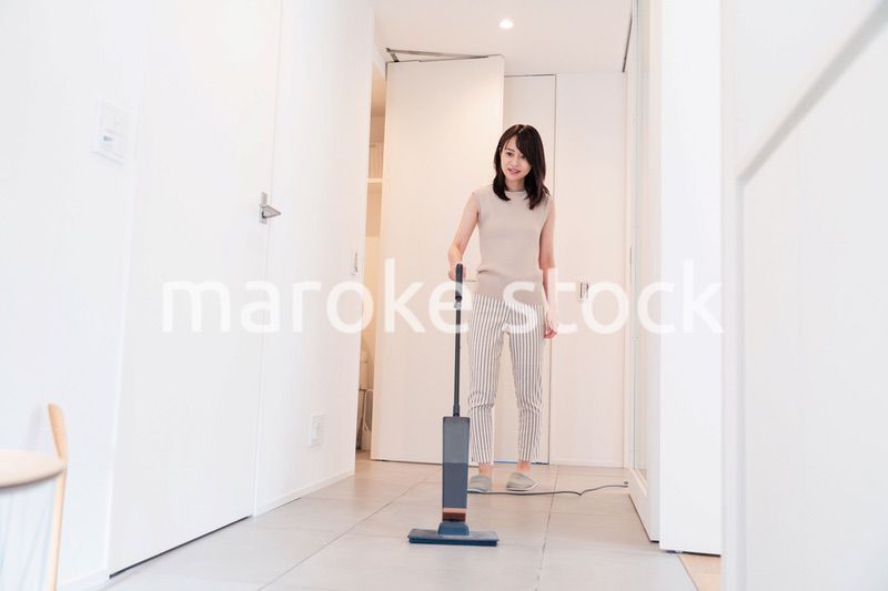 掃除機で家の掃除をする若い女性