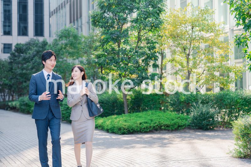 男女で外を歩くビジネスパーソン