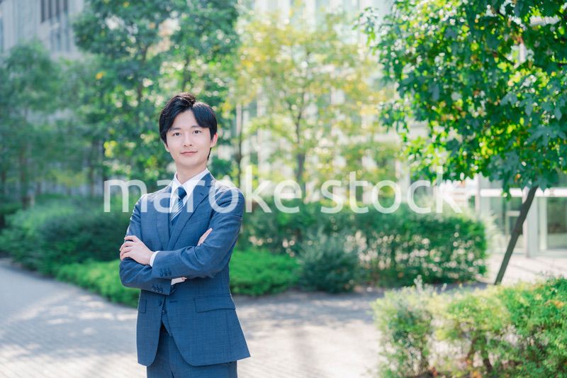 スーツを着て腕を組む若いビジネスマン