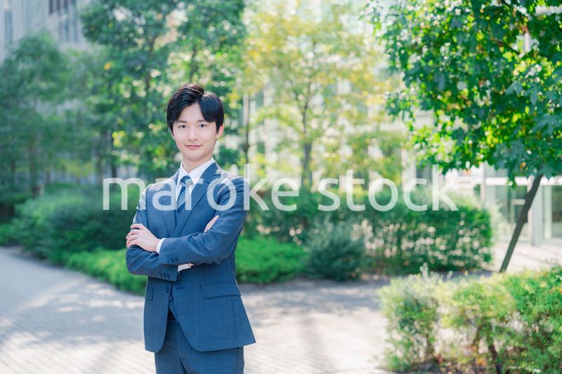 スーツを着て腕を組む若いビジネスマン