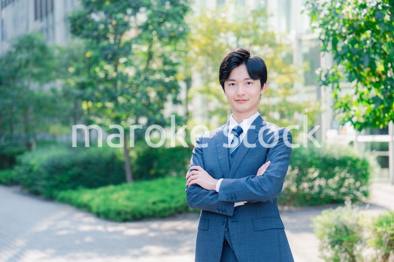 スーツを着て腕を組む若いビジネスマン