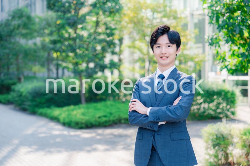 スーツを着て腕を組む若いビジネスマン