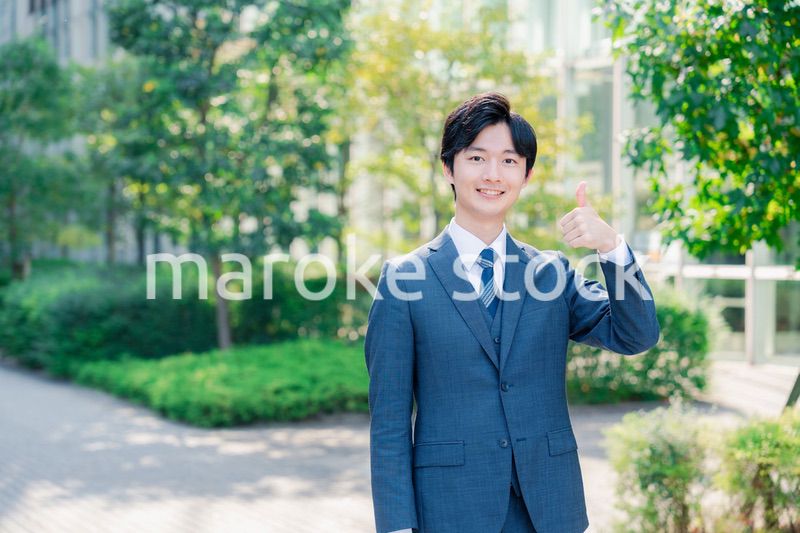 笑顔でOKサインをする若いビジネスマン
