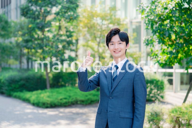 笑顔でOKサインをする若いビジネスマン