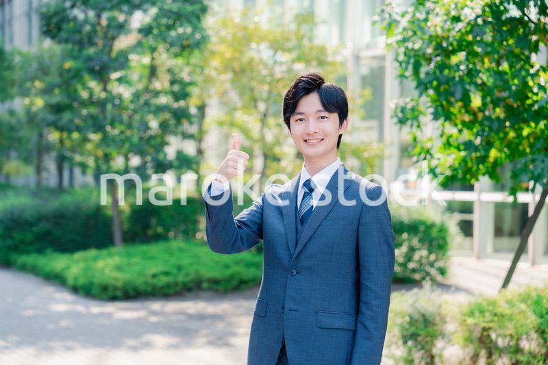 笑顔でOKサインをする若いビジネスマン