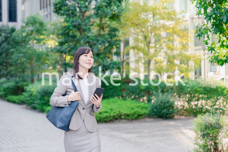 スマホを使いながら歩くビジネスウーマン