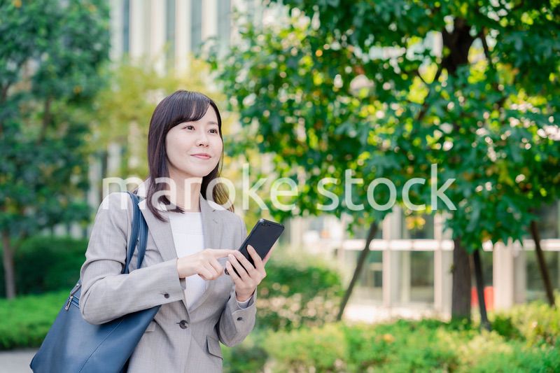 スマホを使いながら歩くビジネスウーマン