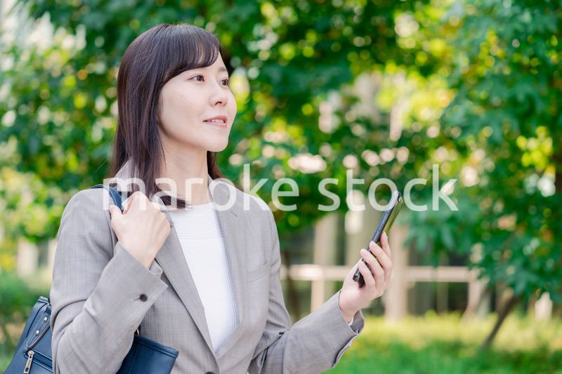 スマホを使いながら歩くビジネスウーマン