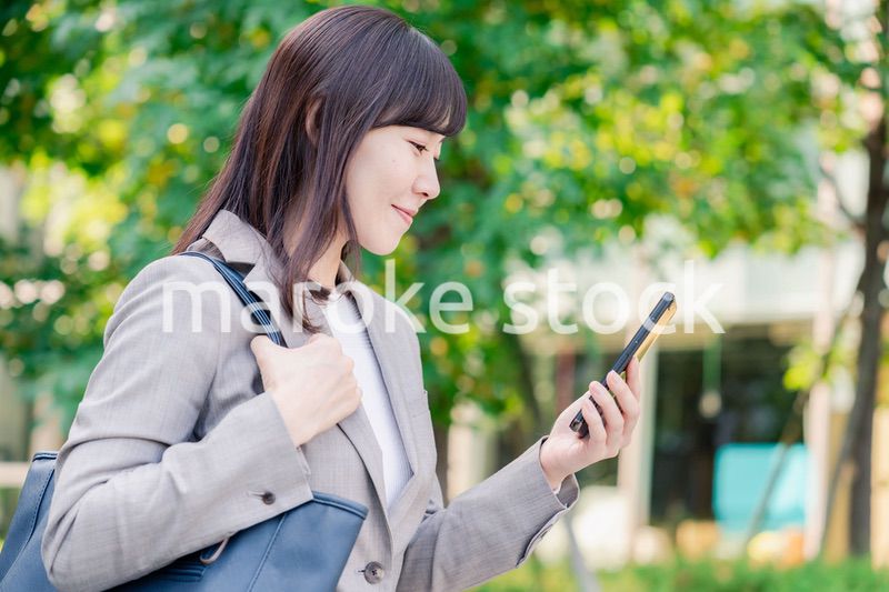 スマホを使いながら歩くビジネスウーマン