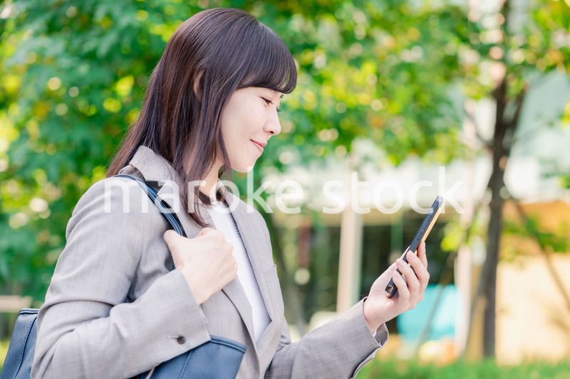 スマホを使いながら歩くビジネスウーマン