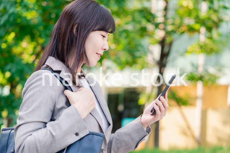 スマホを使いながら歩くビジネスウーマン