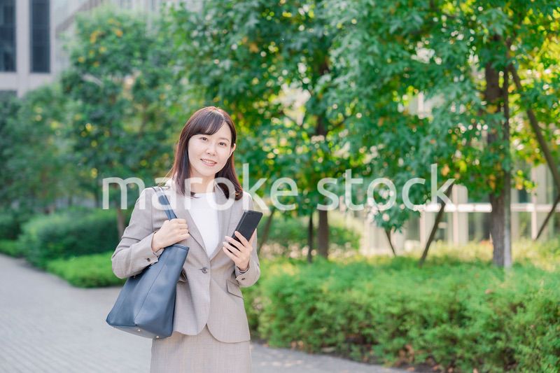 スマホを使いながら歩くビジネスウーマン