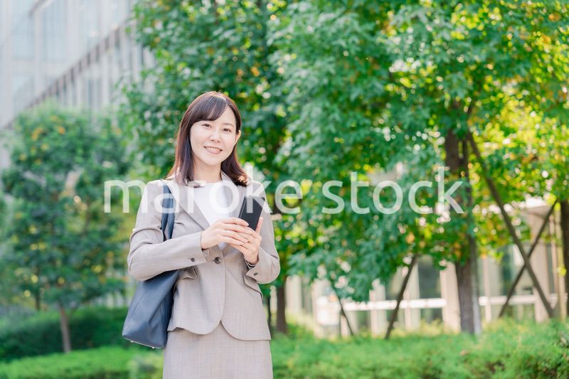 スマホを使いながら歩くビジネスウーマン