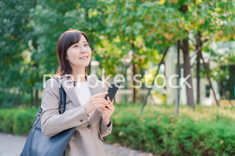 スマホを使いながら歩くビジネスウーマン