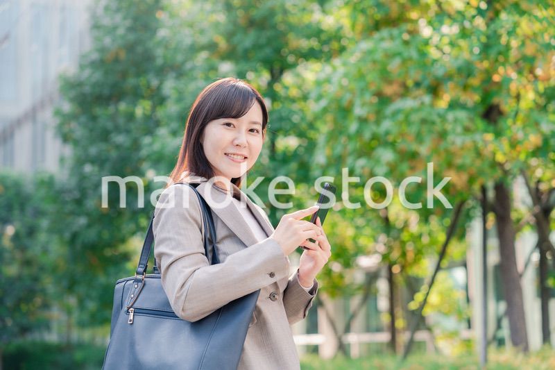 スマホを使いながら歩くビジネスウーマン