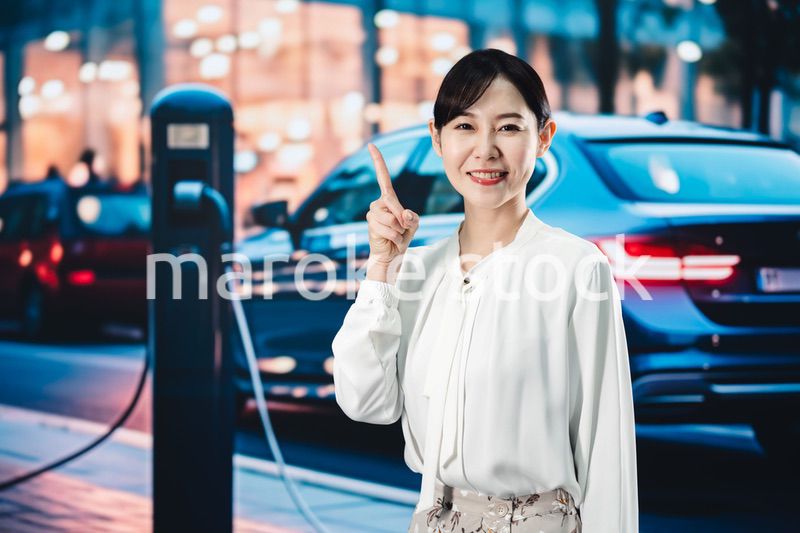 道路で電気自動車を充電する女性