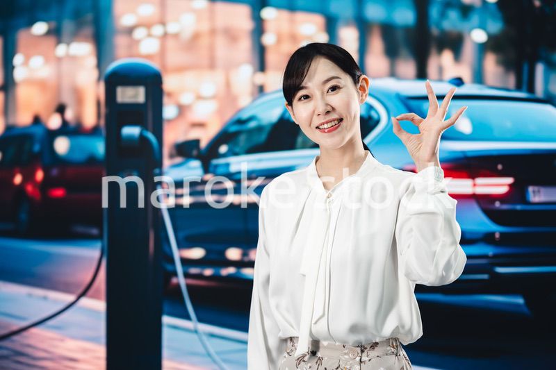 道路で電気自動車を充電する女性