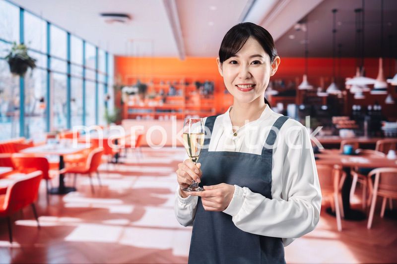 レストランでスパークリングワインを提供する女性