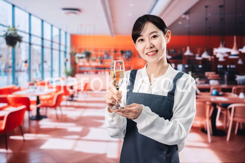 レストランでスパークリングワインを提供する女性