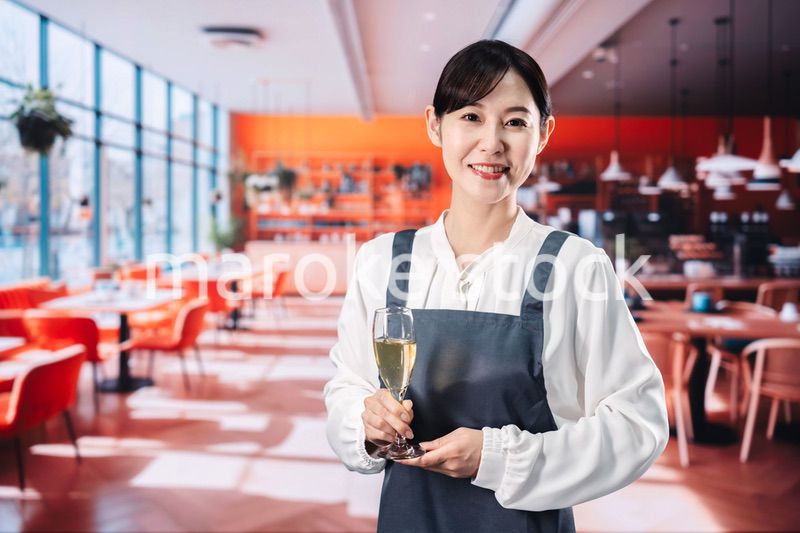 レストランでスパークリングワインを提供する女性
