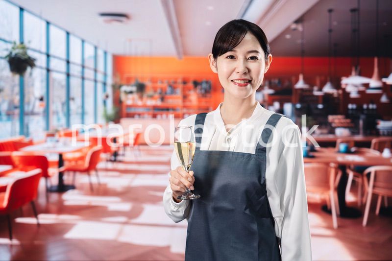 レストランでスパークリングワインを提供する女性