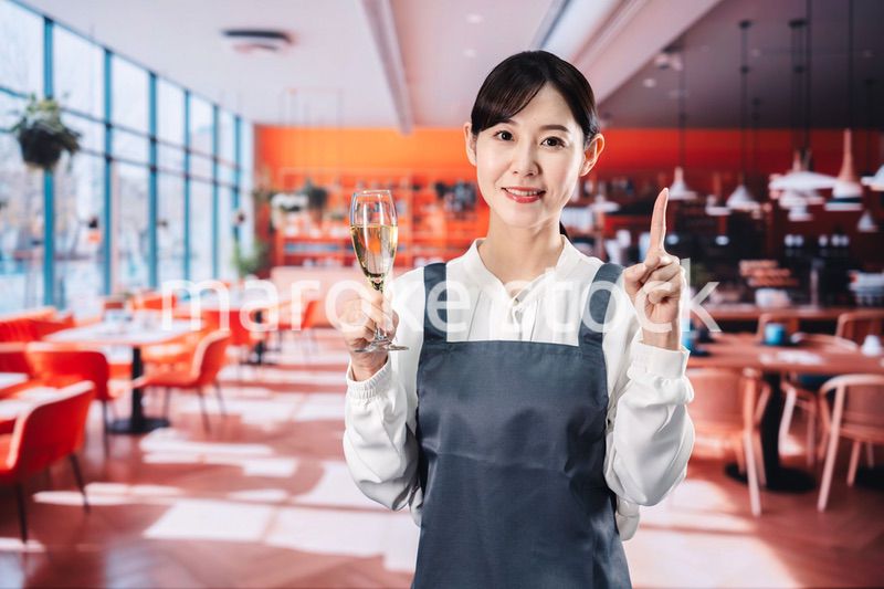 レストランでスパークリングワインを提供する女性