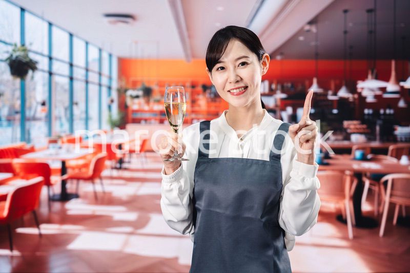 レストランでスパークリングワインを提供する女性