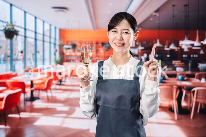 レストランでスパークリングワインを提供する女性