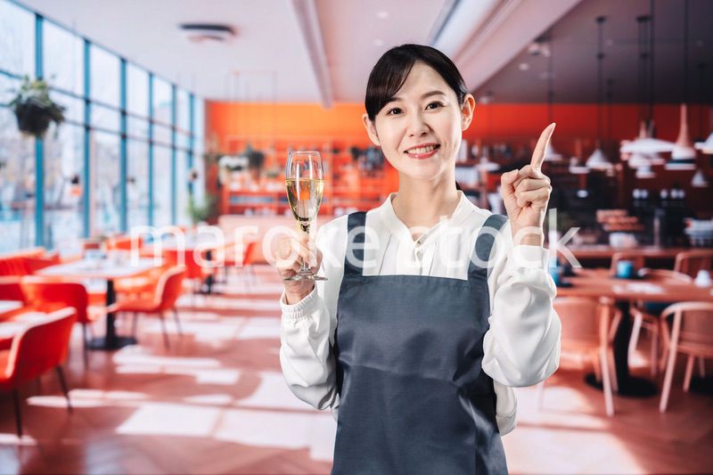 レストランでスパークリングワインを提供する女性