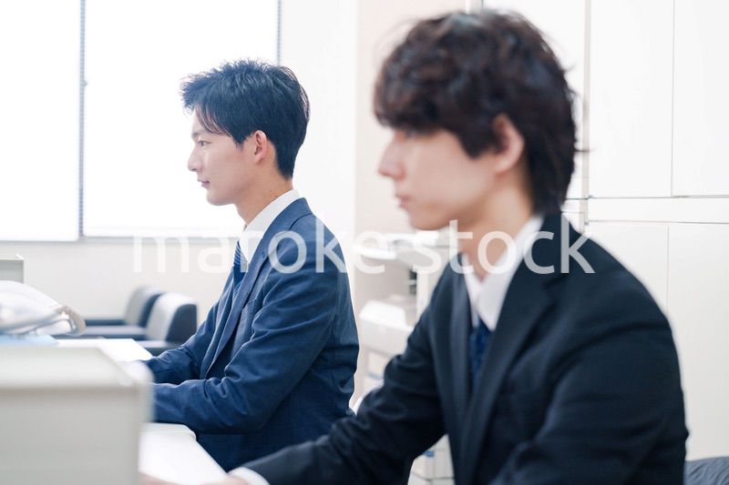 オフィスで集中してデスクワークをするビジネスマン