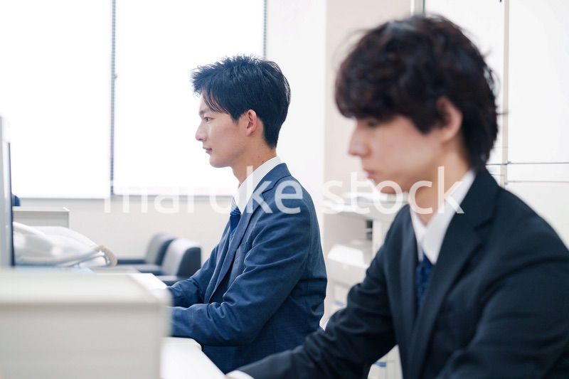 オフィスで集中してデスクワークをするビジネスマン