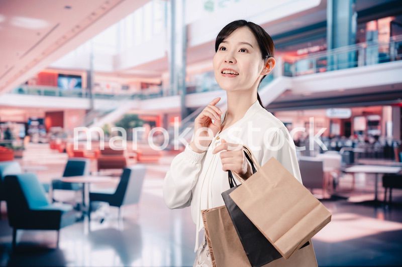 ショッピングモールで福袋を購入する若い女性