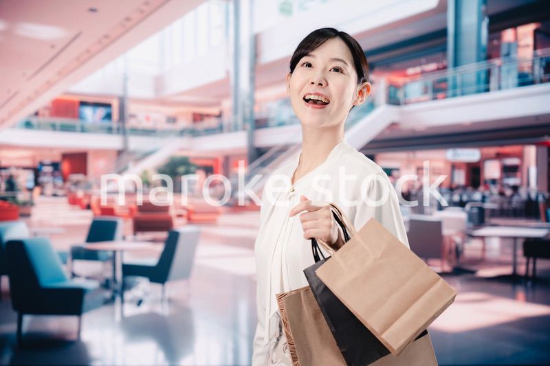 ショッピングモールで福袋を購入する若い女性