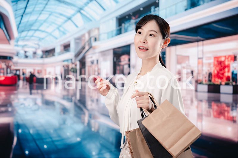 ショッピングモールで福袋を購入する若い女性