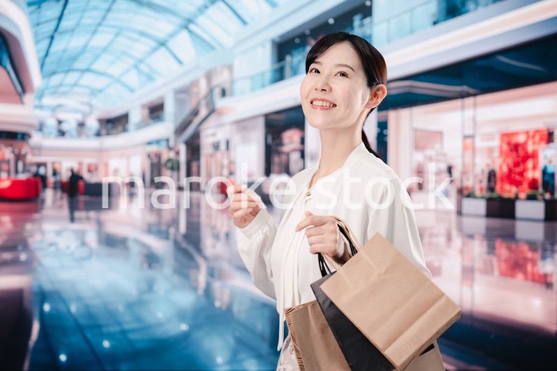 ショッピングモールで福袋を購入する若い女性