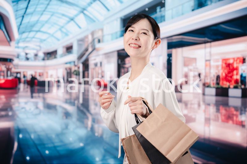 ショッピングモールで福袋を購入する若い女性