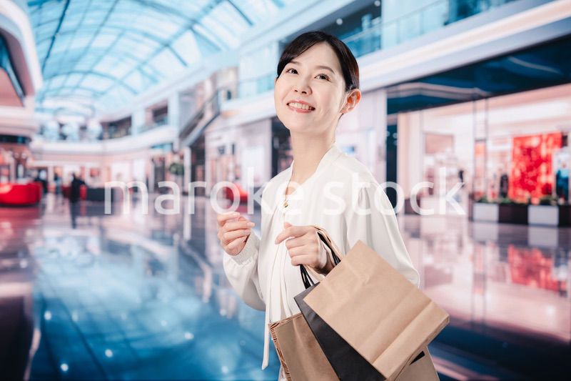 ショッピングモールで福袋を購入する若い女性