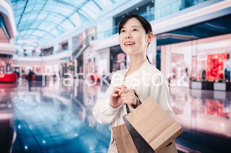 ショッピングモールで福袋を購入する若い女性