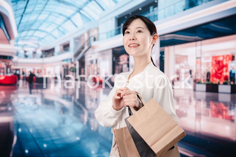 ショッピングモールで福袋を購入する若い女性