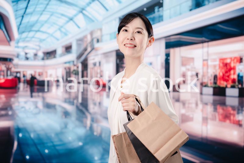 ショッピングモールで福袋を購入する若い女性